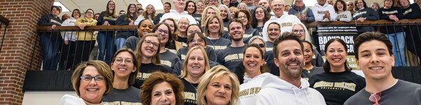 Group shot of Nebraska Wesleyan University employees wear branded sweatshirts